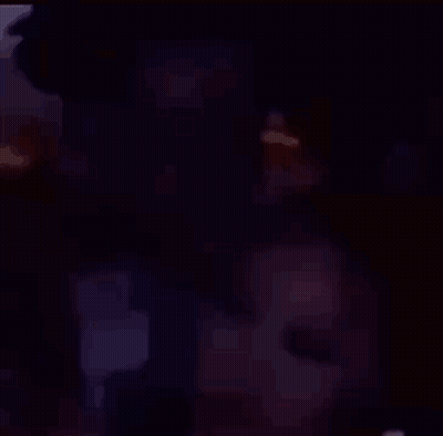 A Man And A Woman Are Sitting Next To Each Other In A Room . GIF