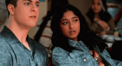 A Man And A Woman Are Sitting Next To Each Other In A Room GIF