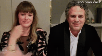 A Man And A Woman Are Sitting Next To Each Other In A Room . The Woman Is Crying And The Man Is Smiling . GIF