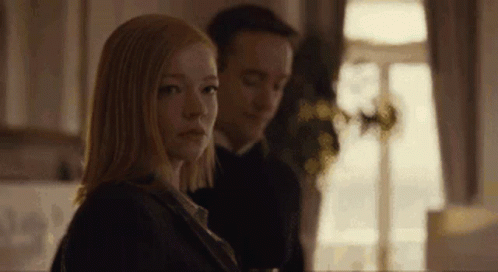 A Man And A Woman Are Sitting Next To Each Other In Front Of A Window . GIF