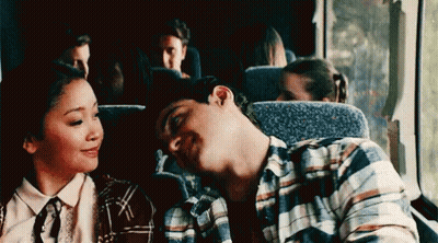 A Man And A Woman Are Sitting Next To Each Other On A Bus And The Man Is Sleeping . GIF