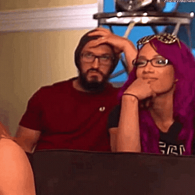 A Man And A Woman Are Sitting Next To Each Other On A Couch . GIF