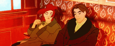 A Man And A Woman Are Sitting Next To Each Other On A Couch GIF