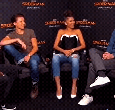 A Man And A Woman Are Sitting Next To Each Other On A Couch Talking . GIF