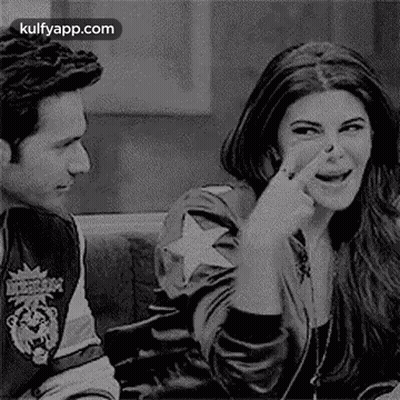 A Man And A Woman Are Sitting Next To Each Other On A Couch . The Woman Is Picking Her Nose . GIF