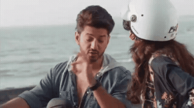 A Man And A Woman Are Sitting Next To Each Other On A Motorcycle . GIF