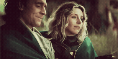 A Man And A Woman Are Sitting Next To Each Other . GIF