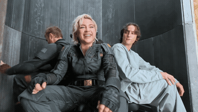 A Man And A Woman Are Sitting Next To Each Other GIF
