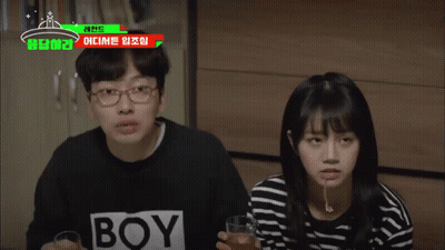 A Man And A Woman Are Sitting Next To Each Other With A Boy Shirt On GIF