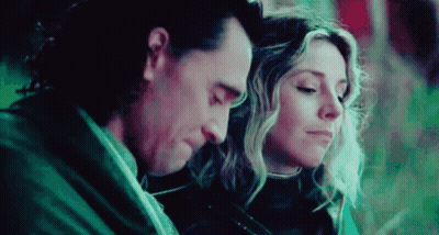 A Man And A Woman Are Sitting Next To Each Other With Their Heads Together . GIF