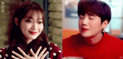 A Man And A Woman Are Sitting Next To Each Other . GIF