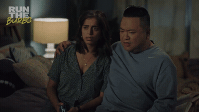A Man And A Woman Are Sitting On A Bed With The Words Run The Burbs Above Them GIF