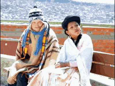 A Man And A Woman Are Sitting On A Bench And The Man Is Wearing A Hat That Says ' A ' On It GIF