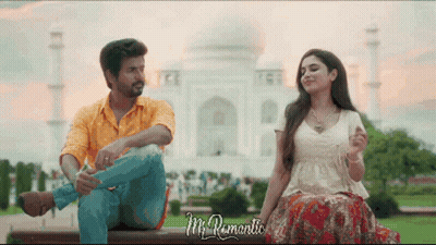 A Man And A Woman Are Sitting On A Bench In Front Of A Mosque And The Words Mr Romantic Are Visible GIF