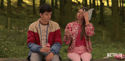 A Man And A Woman Are Sitting On A Bench With Netflix Written On The Bottom GIF