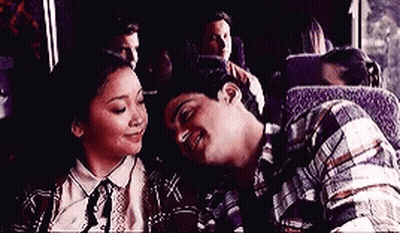 A Man And A Woman Are Sitting On A Bus And Looking At Each Other . GIF
