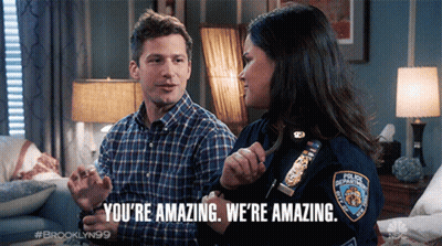 A Man And A Woman Are Sitting On A Couch And The Woman Is Wearing A Badge That Says New York Police Department GIF
