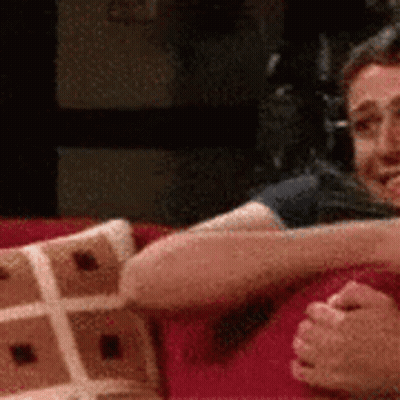 A Man And A Woman Are Sitting On A Couch Holding Hands . GIF