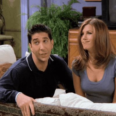 A Man And A Woman Are Sitting On A Couch GIF