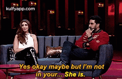 A Man And A Woman Are Sitting On A Couch . GIF