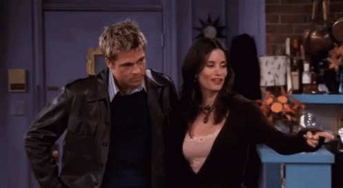A Man And A Woman Are Sitting On A Couch Talking To Each Other GIF