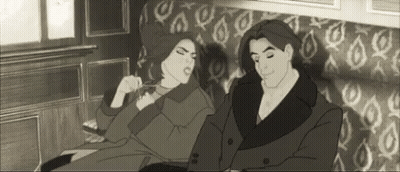 A Man And A Woman Are Sitting On A Couch Together . GIF