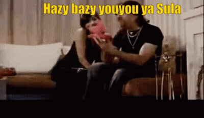 A Man And A Woman Are Sitting On A Couch With Hazy Bazy Youyou Ya Sula Written On The Bottom GIF