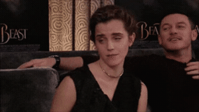 A Man And A Woman Are Sitting On A Couch With The Word Beast Behind Them GIF
