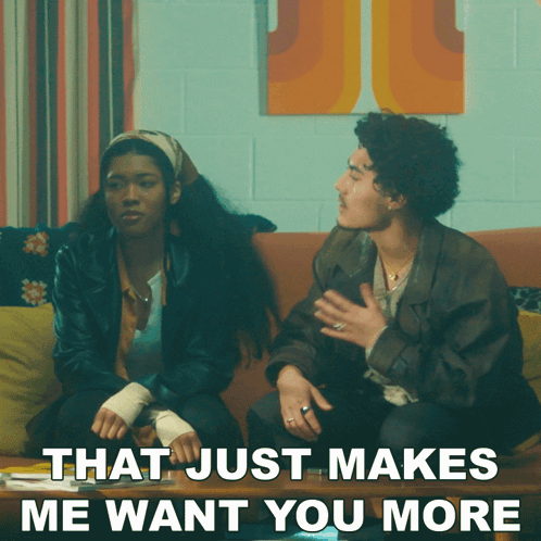 A Man And A Woman Are Sitting On A Couch With The Words That Just Makes Me Want You More GIF