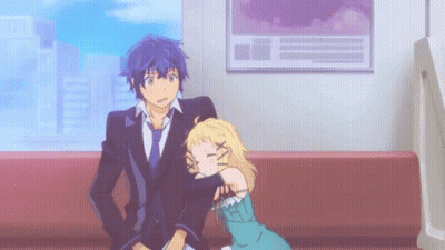 A Man And A Woman Are Sitting On A Couch . GIF