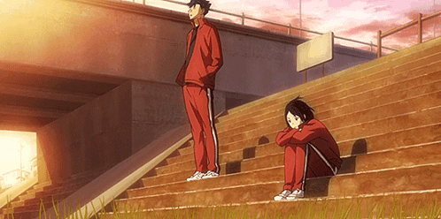 A Man And A Woman Are Sitting On Stairs Under A Bridge . GIF