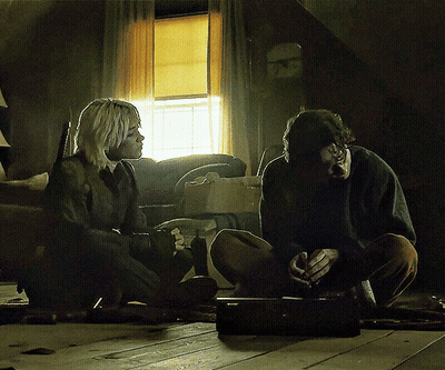 A Man And A Woman Are Sitting On The Floor Talking GIF
