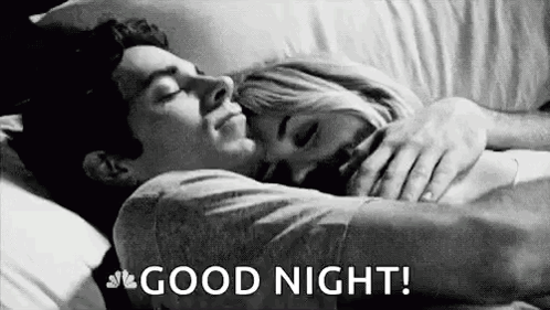 A Man And A Woman Are Sleeping In A Bed And The Man Is Hugging The Woman . GIF