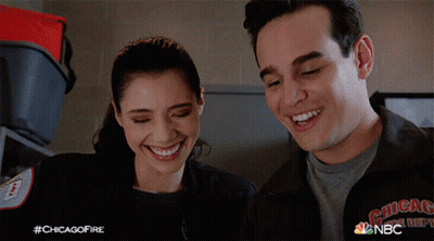 A Man And A Woman Are Smiling And Wearing A Jacket That Says Chicago Fire Department GIF