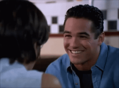 A Man And A Woman Are Smiling At Each Other While Sitting At A Table . GIF