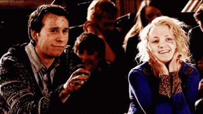 A Man And A Woman Are Smiling In Front Of A Sign That Says Rita Parley On It GIF