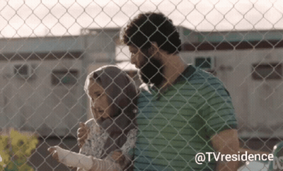 A Man And A Woman Are Standing Behind A Chain Link Fence With The Hashtag Tvresidence On The Bottom GIF