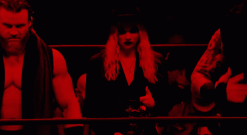 A Man And A Woman Are Standing In A Dark Room With Red Lights GIF
