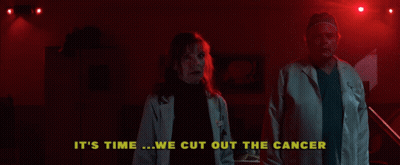 A Man And A Woman Are Standing In A Dark Room With The Words " It 'S Time We Cut Out The Cancer " Above Them GIF