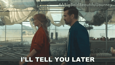 A Man And A Woman Are Standing In A Greenhouse And The Man Is Saying " I 'Ll Tell You Later " GIF