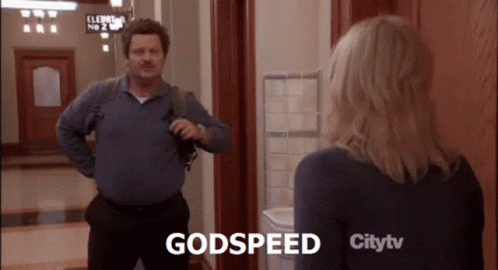 A Man And A Woman Are Standing In A Hallway And The Man Says Godspeed GIF