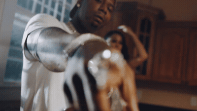 A Man And A Woman Are Standing In A Kitchen GIF