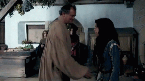 A Man And A Woman Are Standing In A Room Talking To Each Other GIF