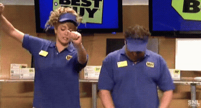 A Man And A Woman Are Standing In Front Of A Best Buy Sign . GIF