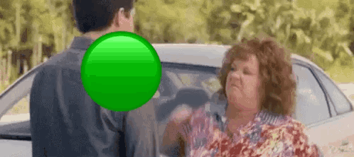 A Man And A Woman Are Standing In Front Of A Car . GIF