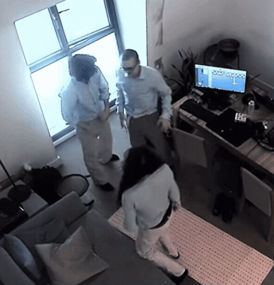 A Man And A Woman Are Standing In Front Of A Computer Monitor That Says ' Olympus ' On The Screen GIF