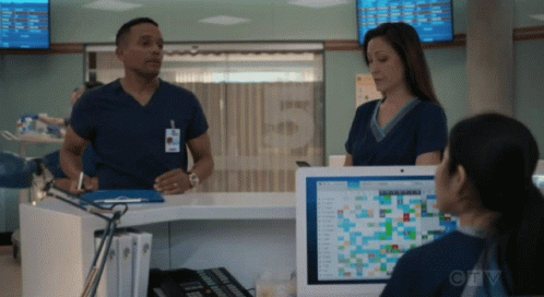 A Man And A Woman Are Standing In Front Of A Computer Screen With The Letters Ctv On It GIF