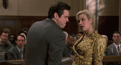 A Man And A Woman Are Standing In Front Of A Crowd In A Court Room GIF