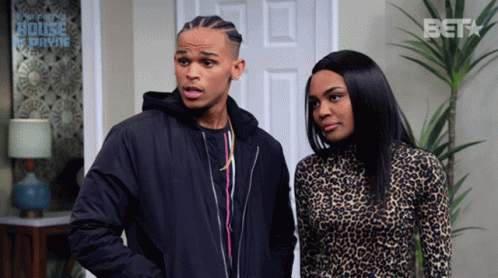 A Man And A Woman Are Standing In Front Of A Door That Says Bet GIF