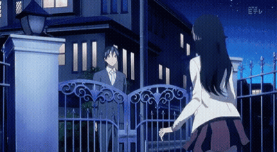 A Man And A Woman Are Standing In Front Of A Fence With The Letters E On The Bottom Left GIF